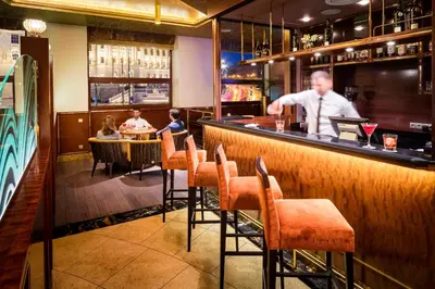 a man standing at a bar in a restaurant at Occidental Praha Wilson in Prague