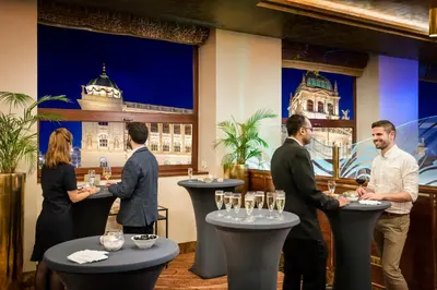 a group of people standing around a bar with wine glasses at Occidental Praha Wilson in Prague
