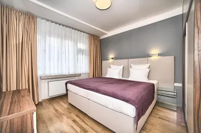a bedroom with a large bed with a purple blanket at Art Residence Krocinova in Prague