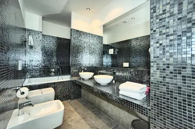 a black tiled bathroom with two sinks and a toilet at Art Residence Krocinova in Prague