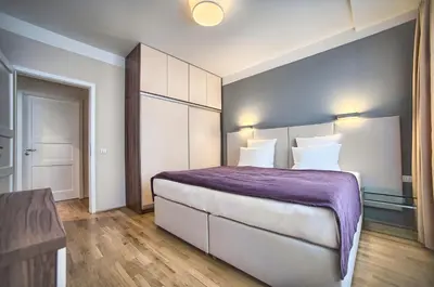 a bedroom with a large bed with a purple blanket at Art Residence Krocinova in Prague