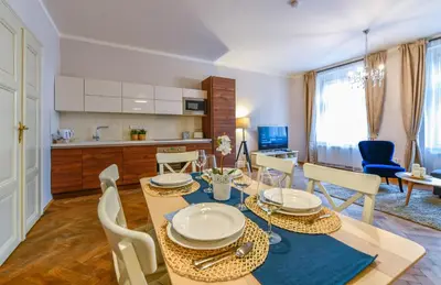 a kitchen and dining room with a table and chairs at Apartments Rybná in Prague