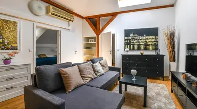 a living room with a couch and a tv at Apartments Rybná in Prague