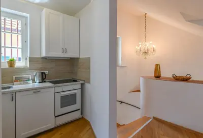 a kitchen with white cabinets and a counter top at Apartments Rybná in Prague