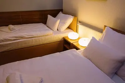 a hotel room with two beds and a side table at Hotel Na Šustně in Krupá