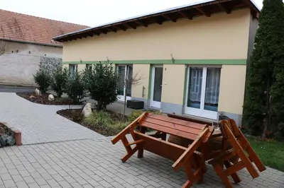 a wooden bench sitting in front of a building at Penzion Kotvas in Milovice