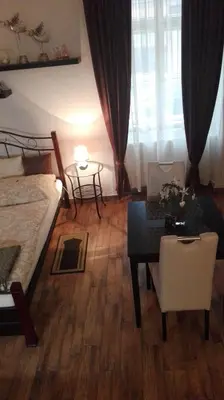 a bedroom with a bed and a table and a room with a desk at Apartment Jakubská 676 in Prague