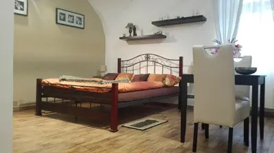 a bedroom with a bed and a table and a chair at Apartment Jakubská 676 in Prague