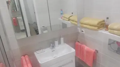 a bathroom with a sink and a mirror and towels at Apartment Jakubská 676 in Prague