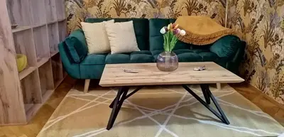 a green couch with a vase of flowers on a coffee table at Apartment Jakubská 676 in Prague