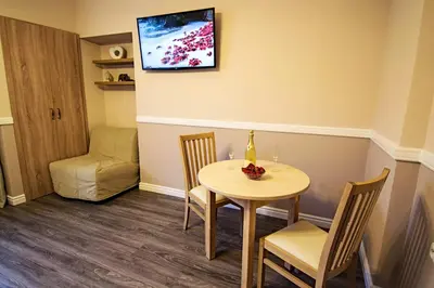 a dining room with a table and chairs and a tv at Champagne Studio with Sauna in Prague