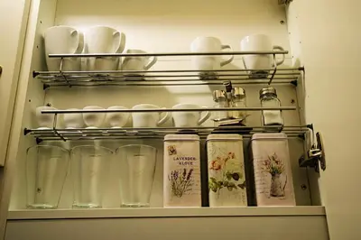 a shelf with glasses and cups on it at Champagne Studio with Sauna in Prague