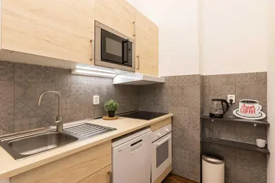 a small kitchen with a sink and a microwave at Apartment Na Kozacce 6 in Prague