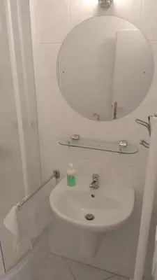 a white bathroom with a sink and a mirror at Guest House Kaskáda in Vrané nad Vltavou