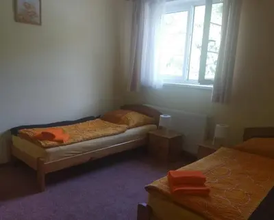 a small bedroom with two beds and a window at Guest House Kaskáda in Vrané nad Vltavou