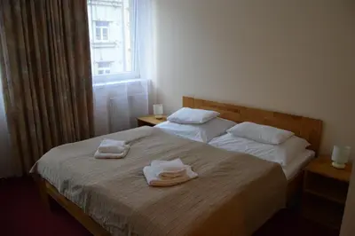a bedroom with two towels on a bed with a window at HOTEL ARÉNA in Prague