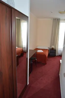 a hotel room with two beds and a mirror at HOTEL ARÉNA in Prague
