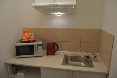 a kitchen counter with a microwave and a sink at HOTEL ARÉNA in Prague