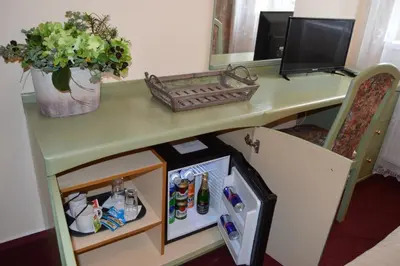 a table with a small refrigerator under a desk at HOTEL ARÉNA in Prague