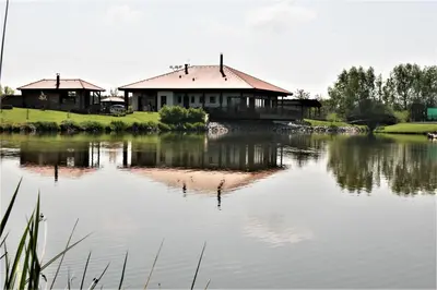 a house on the shore of a lake at Rooms & Restaurace Na Jitrách in Semice