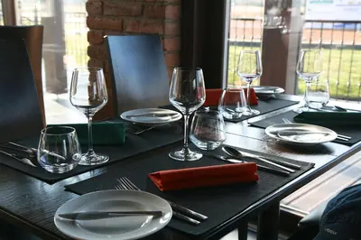 a table with plates and wine glasses on it at Rooms & Restaurace Na Jitrách in Semice