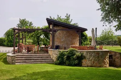 a gazebo with a table and chairs in a yard at Rooms & Restaurace Na Jitrách in Semice