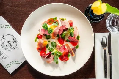 a plate of food with meat and vegetables on a table at Rooms & Restaurace Na Jitrách in Semice
