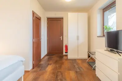 a bedroom with a bed and a flat screen tv at Rooms & Restaurace Na Jitrách in Semice