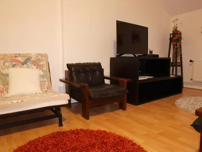 a living room with a chair and a tv at Attic Apartment City Center in Prague