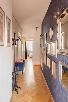 a hallway with a blue accent wall and a fireplace at Maiselova House in Prague