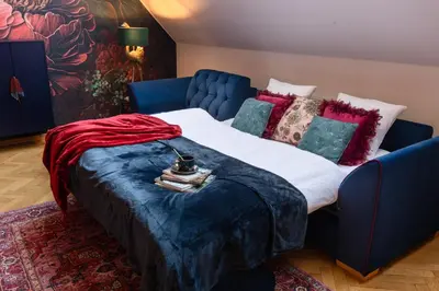 a bedroom with a large bed with a blue couch at Maiselova House in Prague