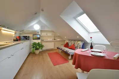 a kitchen and a living room with a table and a couch at A. V. Pension Praha in Prague
