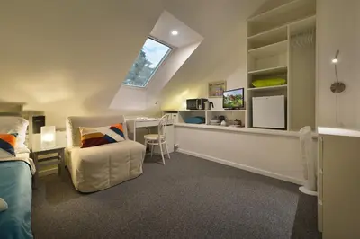 a attic room with a desk and a chair at A. V. Pension Praha in Prague