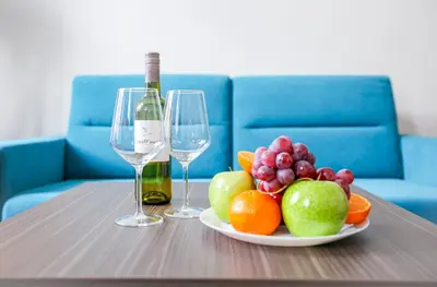 a table with a plate of fruit and two wine glasses at Apartments Embassy by LH in Prague