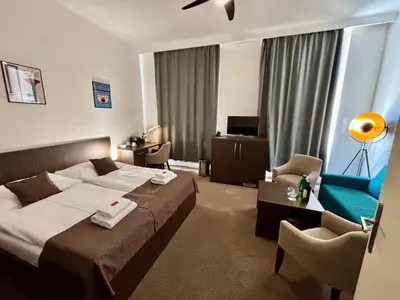 a hotel room with a bed and a chair at Apartments Embassy by LH in Prague