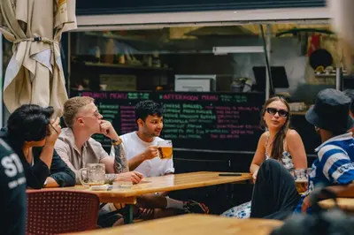 a group of people sitting at a table in a restaurant at Drunken Monkey Hostel in Prague