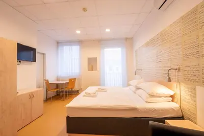 a bedroom with a bed and a desk in a room at Drunken Monkey Hostel in Prague