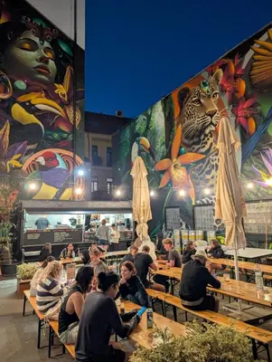 a group of people sitting at tables in a restaurant at Drunken Monkey Hostel in Prague