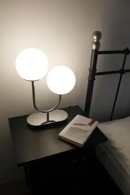two lamps on a table next to a bed with a book at Modern apartment Michalska 6 in Prague