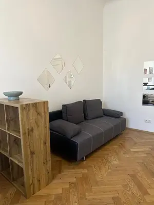 a black couch in a room with a wooden cabinet at Apartment Skorepka 4 in Prague