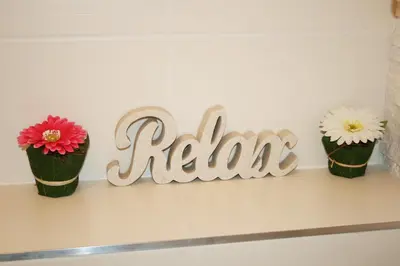 a sign for a room with three flower pots on a shelf at Apartment Lea in Prague