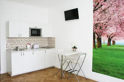 a white kitchen with a table and a window at Apartment Lea in Prague
