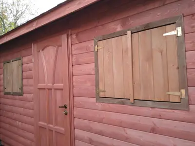 a red shed with two windows and a door at Prague Retro Challenge and Garden in Prague
