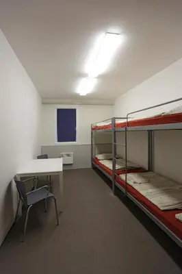 a room with bunk beds and a table and a desk at Labe Aréna Račice in Štětí
