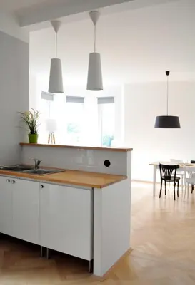 a kitchen with white cabinets and a table at Central-Modern-Apartment in Prague