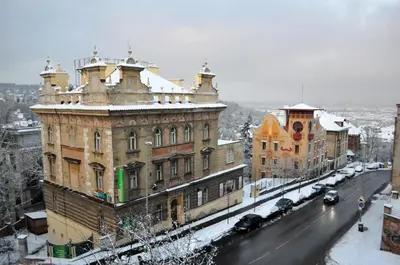 an old building with snow on it on a city street at Central-Modern-Apartment in Prague
