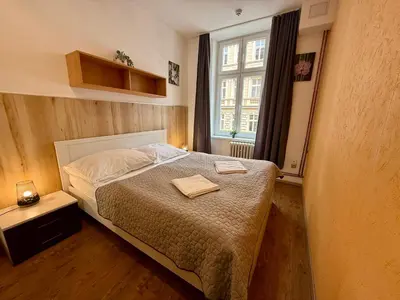 a small bedroom with a bed and a window at Pension SKLEP in Prague