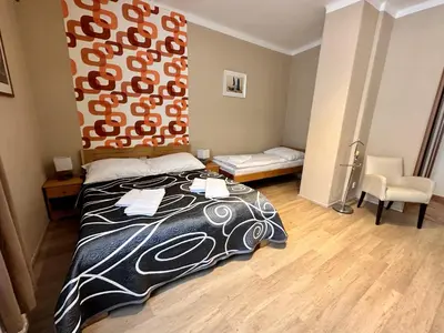 a bedroom with a bed with a black and white blanket at Pension SKLEP in Prague