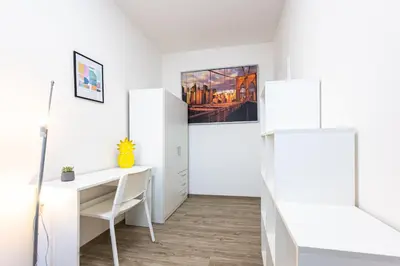 a white room with a desk and a bed at Apartment Americká 8 in Prague