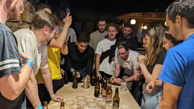 a group of people standing around a table with bottles at Onefam Old Town in Prague
